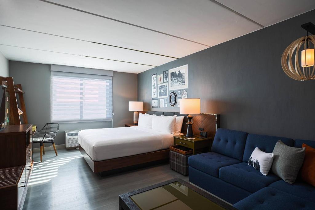 布卢明顿Renaissance Minneapolis Bloomington Hotel的一间卧室配有一张床和一张蓝色的沙发