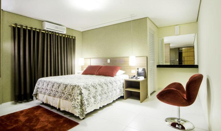乌穆阿拉马ROMA'S HOTEL的一间卧室配有一张床和一把椅子