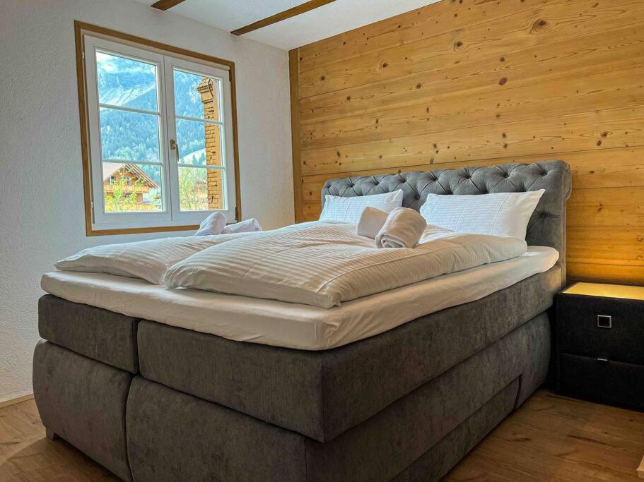 坎德施泰格Alpine Chalet的窗户客房内的一张大床