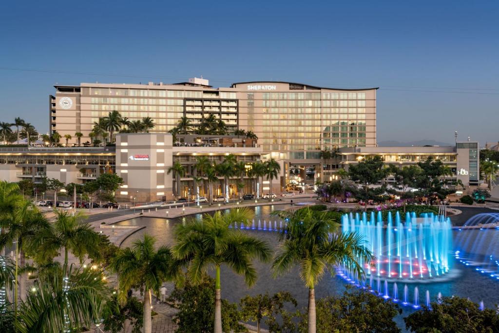 圣胡安Sheraton Puerto Rico Resort & Casino的一座棕榈树大建筑,喷泉