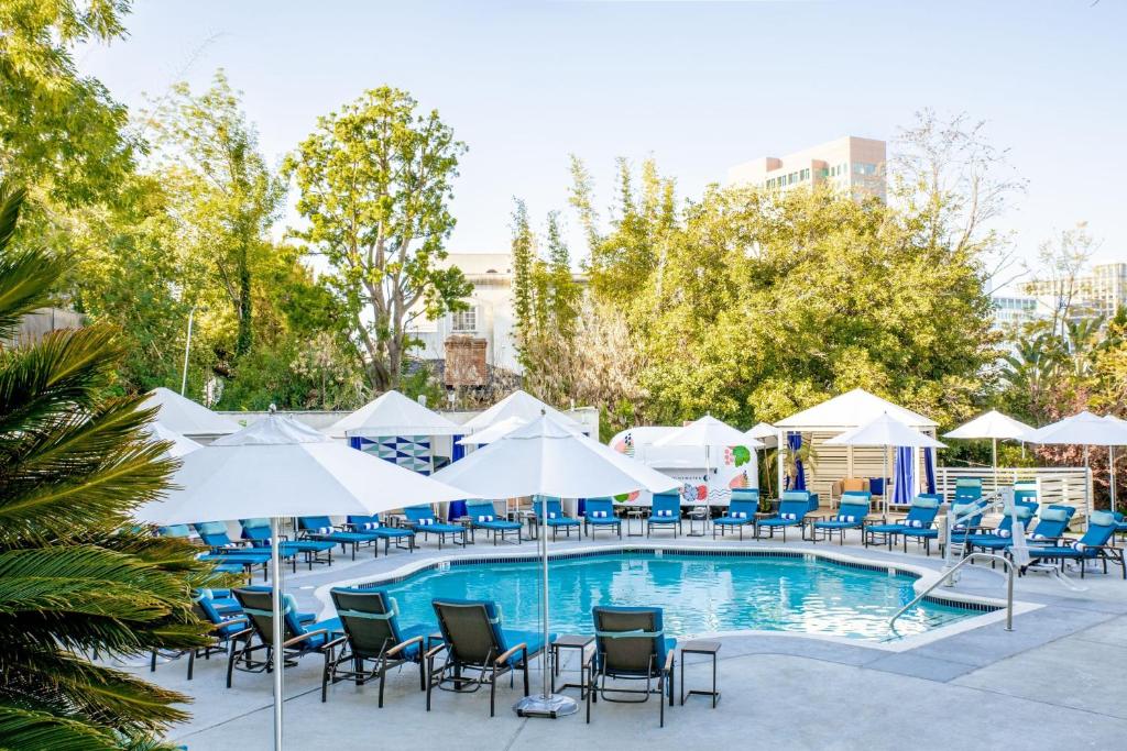 洛杉矶洛杉矶西比佛利山庄W酒店的一个带椅子和遮阳伞的游泳池