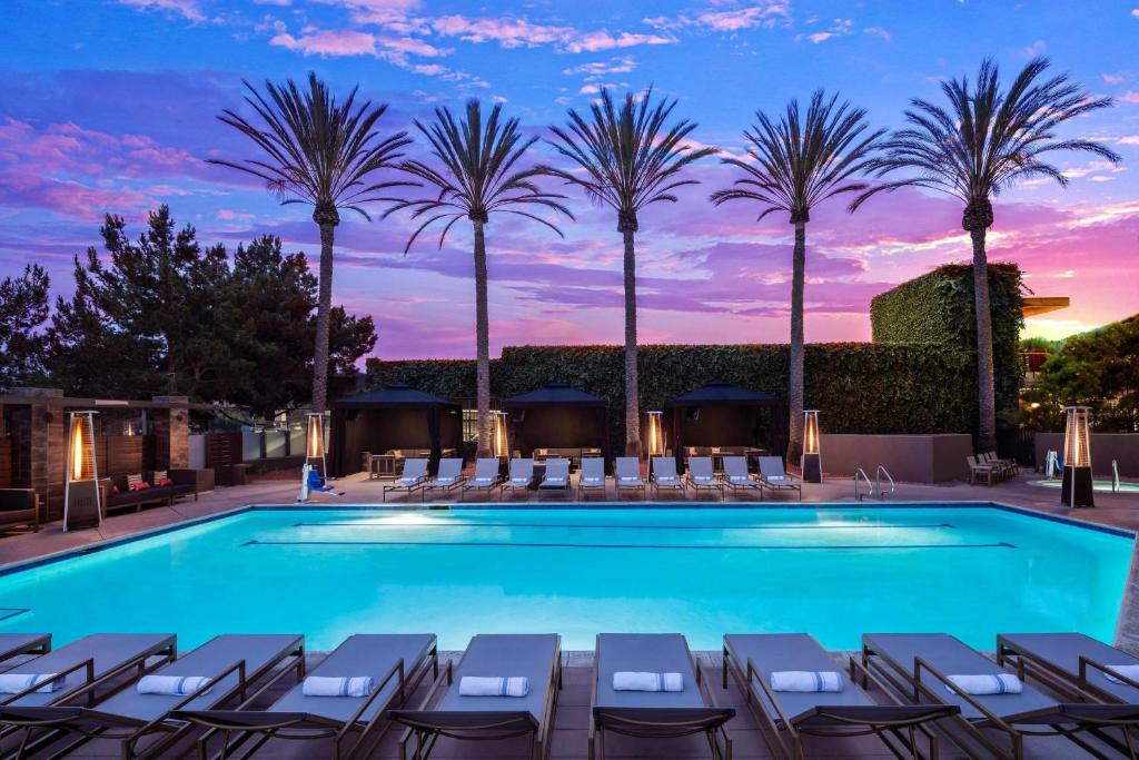 圣地亚哥圣地亚哥德尔马万豪酒店的黄昏时分,游泳池里设有椅子和棕榈树