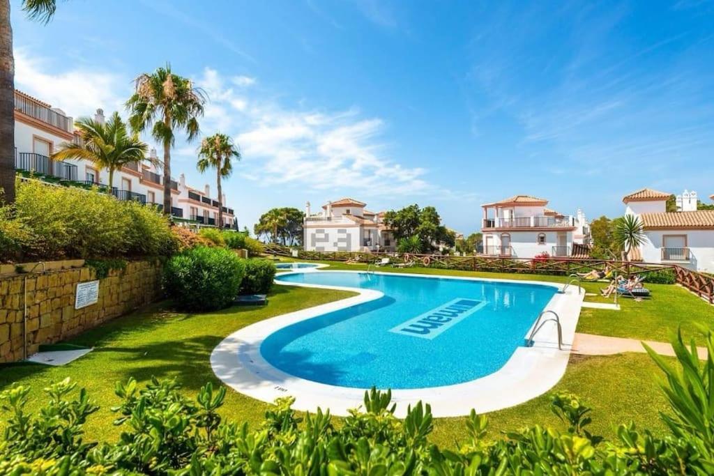 马贝拉Jolie maison à Cabopino Marbella的一座带房屋的院子中的游泳池的形象