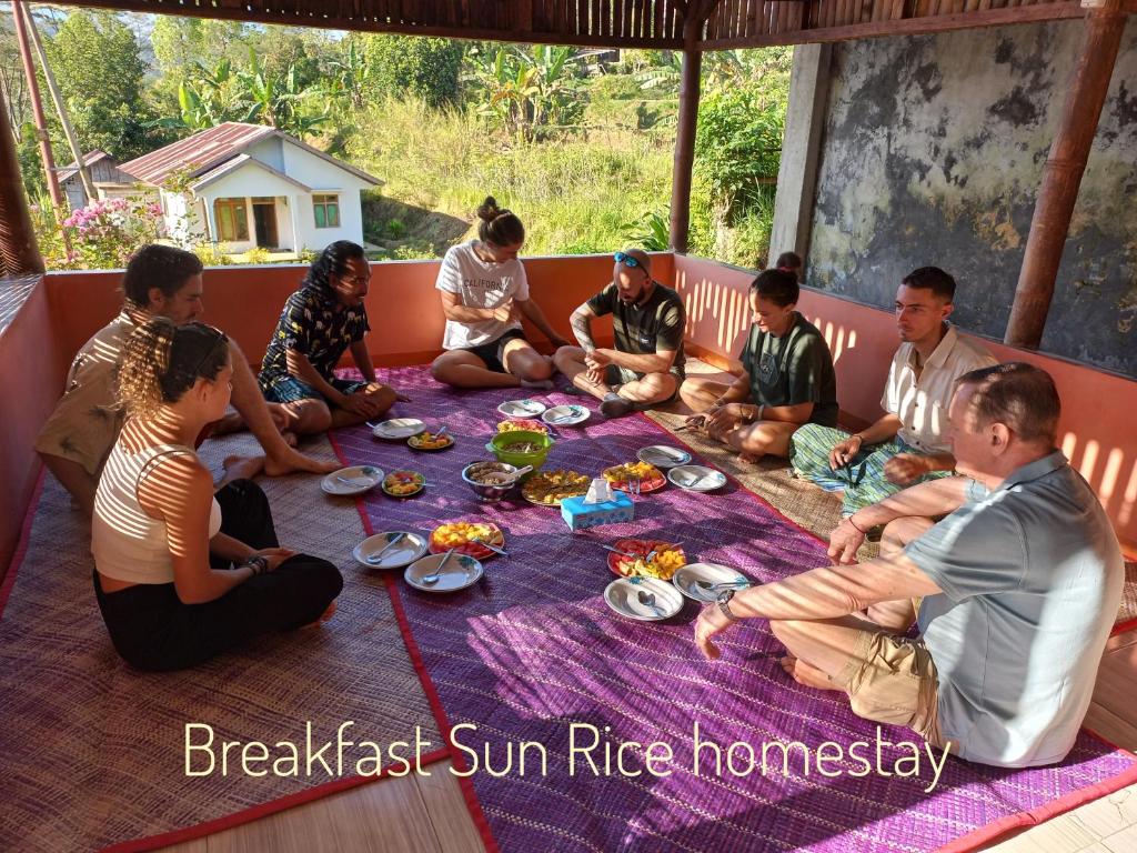 鲁滕Sun Rice Homestay的一群坐在桌子旁吃食物的人