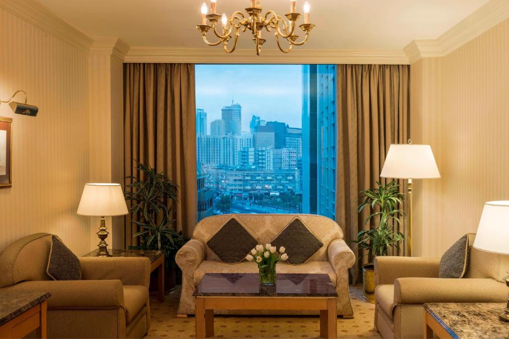 科威特Sheraton Kuwait, a Luxury Collection Hotel, Kuwait City的客厅配有椅子和大窗户
