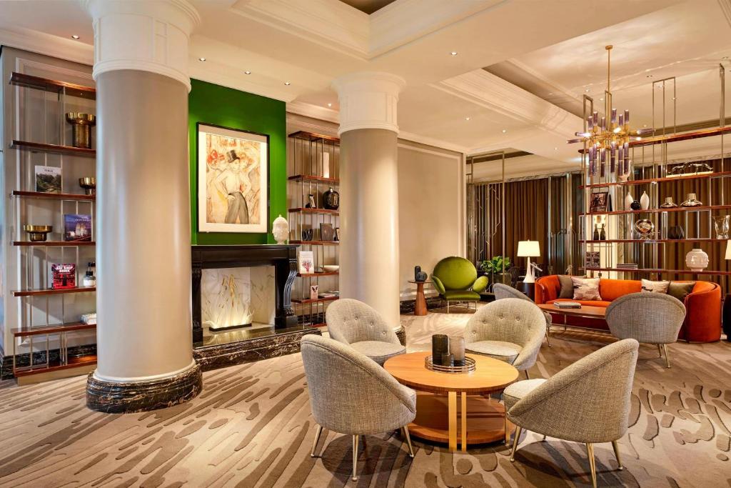柏林柏灵丽思卡尔顿酒店的客厅配有椅子、桌子和壁炉