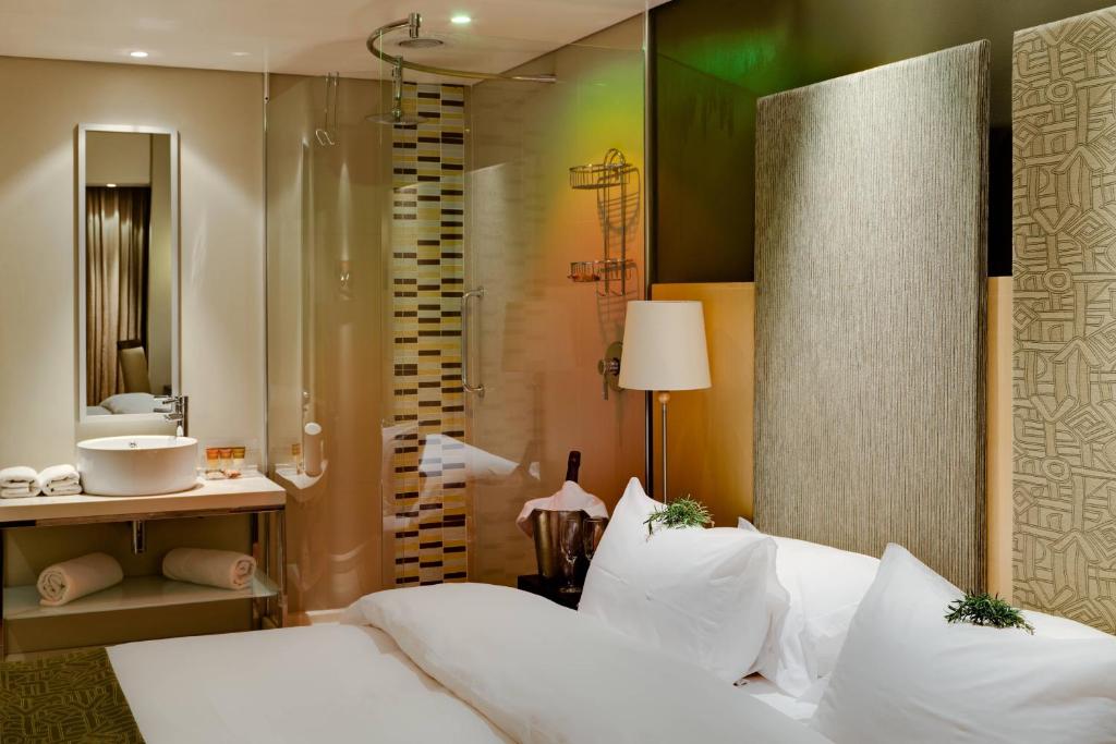 布隆方丹布隆方丹柳树湖万豪Protea酒店的一间卧室配有一张床,浴室设有淋浴。