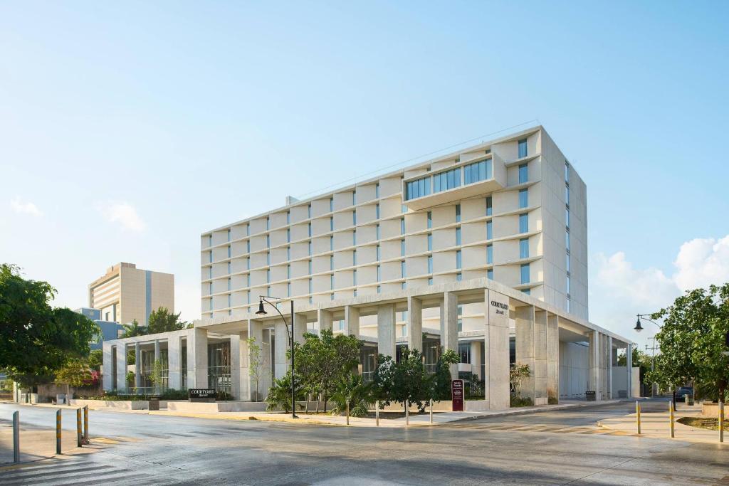 梅里达Courtyard by Marriott Merida Downtown的前面有一条街道的白色大建筑