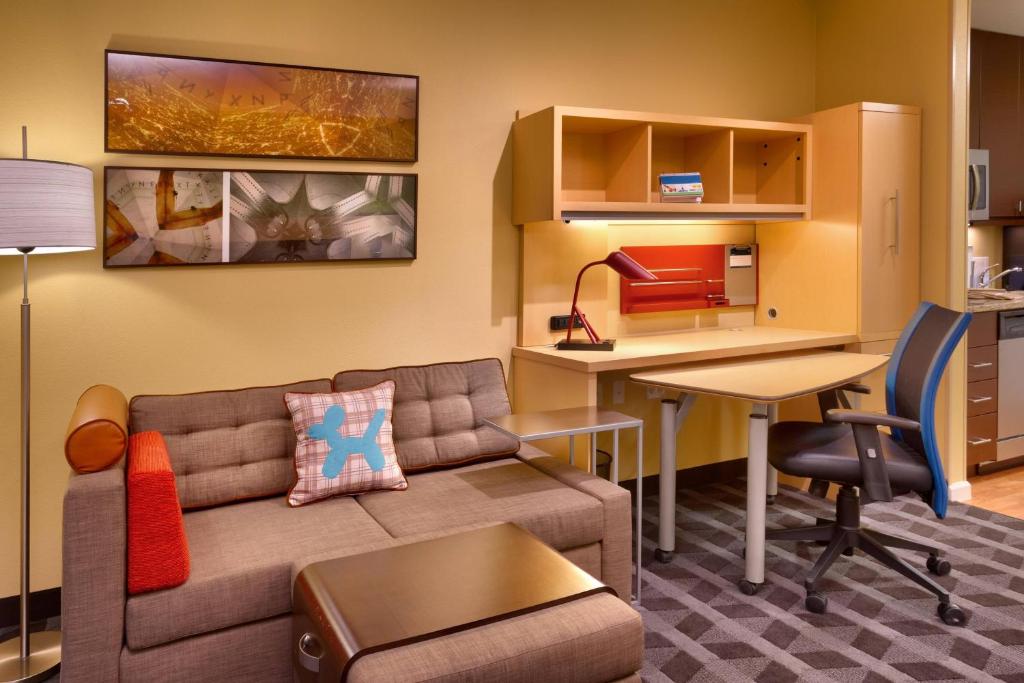 迪金森TownePlace Suites by Marriott Dickinson的客厅配有沙发、桌子和书桌