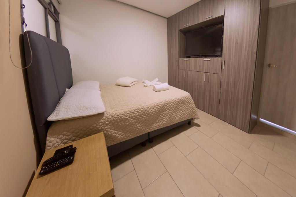 佩雷拉Ventiuna Hotel y Coliving的小房间设有床和电视