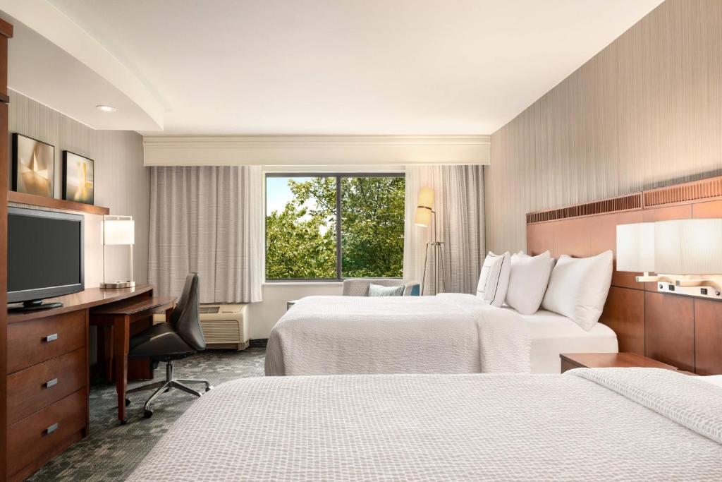 North Wales费城蒙哥马利万怡酒店的酒店客房设有两张床、一张桌子和一台电视。