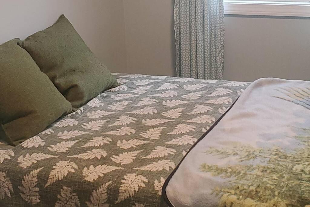 Adorable 1 bedroom with off-street parking的一张带毯子的床和两个枕头