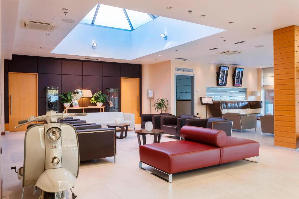 泰塞拉万豪威尼斯机场酒店的一间设有红色沙发和椅子的等候室