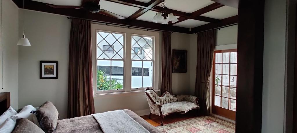 陶朗加Delightful on Devonport的一间卧室配有一张床、一把椅子和窗户。