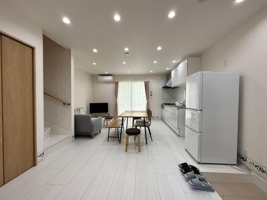 KanayamaSHIRAHAMA condominium D-100的厨房配有冰箱和桌椅