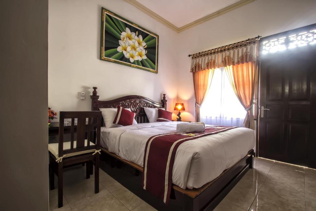 努沙杜瓦素馨民宿的卧室配有床、椅子和窗户。