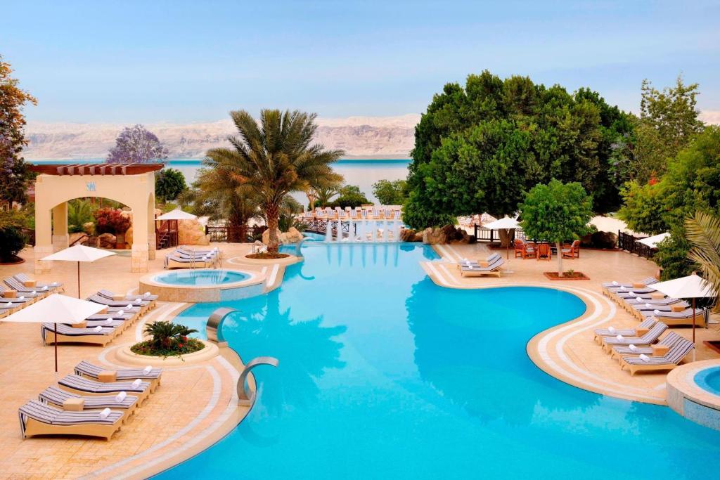 索瓦马死海万豪酒店&度假村的一个带躺椅和水的游泳池的度假酒店
