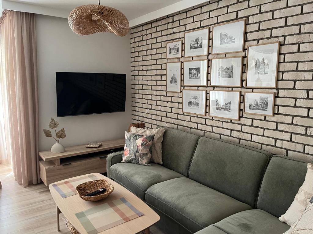 比亚韦斯托克Apartament Akademicka的客厅设有绿色沙发和砖墙