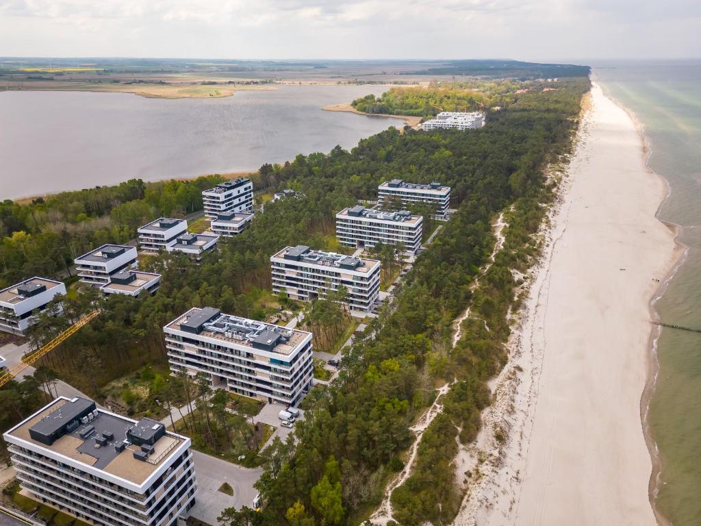 洛格沃Apartament Shellter Sun&Sea Rogowo koło Kołobrzegu_Dźwirzyno_nocleg的享有海滩和建筑的空中景致