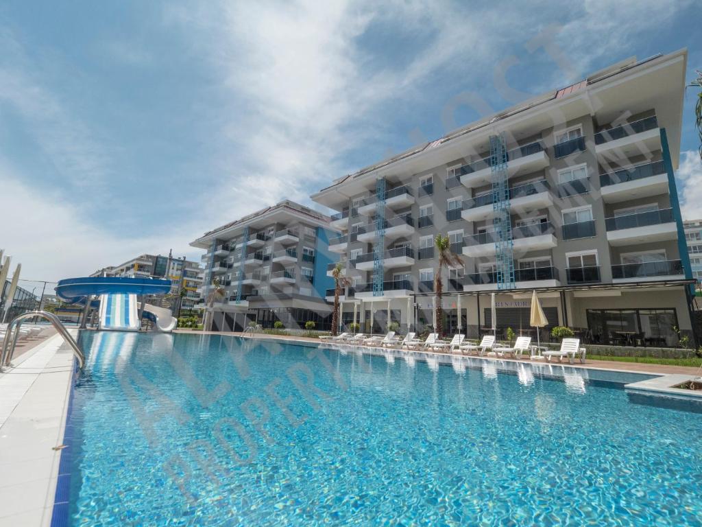 阿拉尼亚Calypso Residence Luxurious Beachside Apartment in Alanya D6的大楼前的大型游泳池