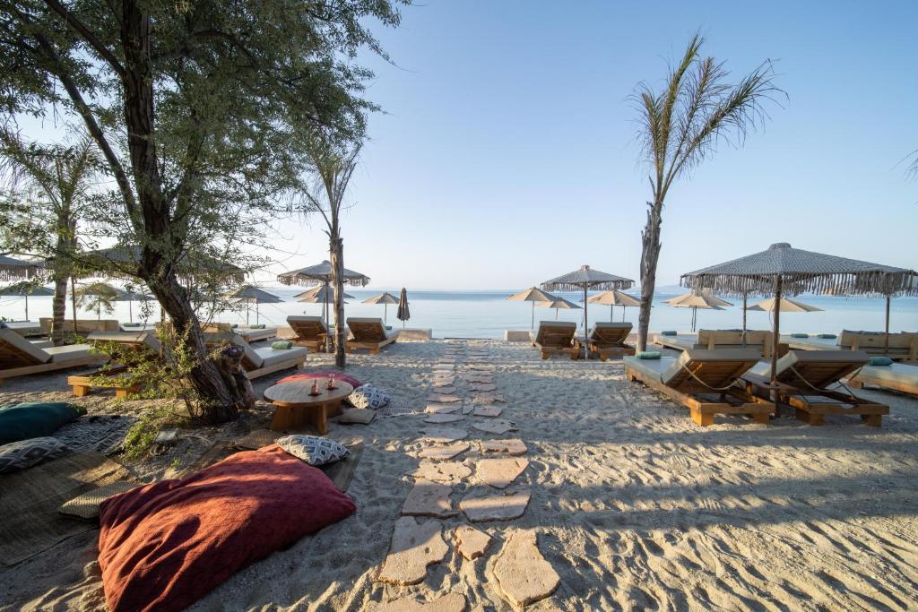 佩科霍里MAKO Sea & Suites的海滩上设有椅子和遮阳伞,还有大海