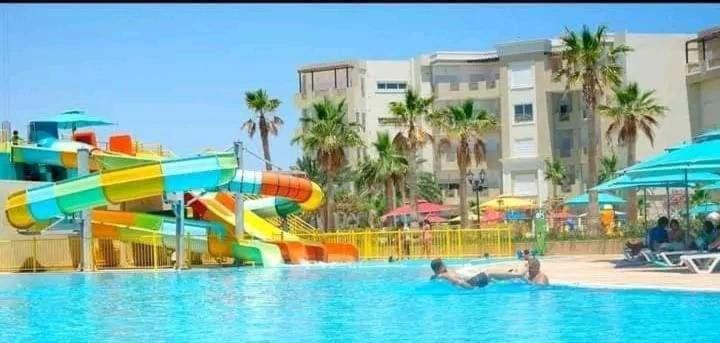 莫纳斯提尔Palm lake resort Folla Monastir的度假村内带水滑梯的游泳池