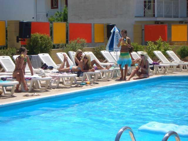 卡沃斯Kavos Central的一群人坐在游泳池附近的椅子上