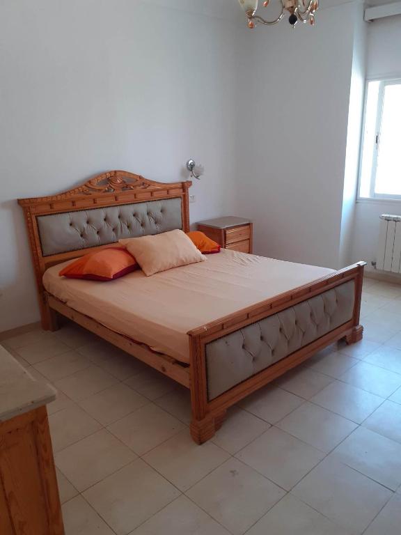 哈马马特Villa bien équipée à Hammamet centre (200m de la plage)的一间卧室配有一张大木床。