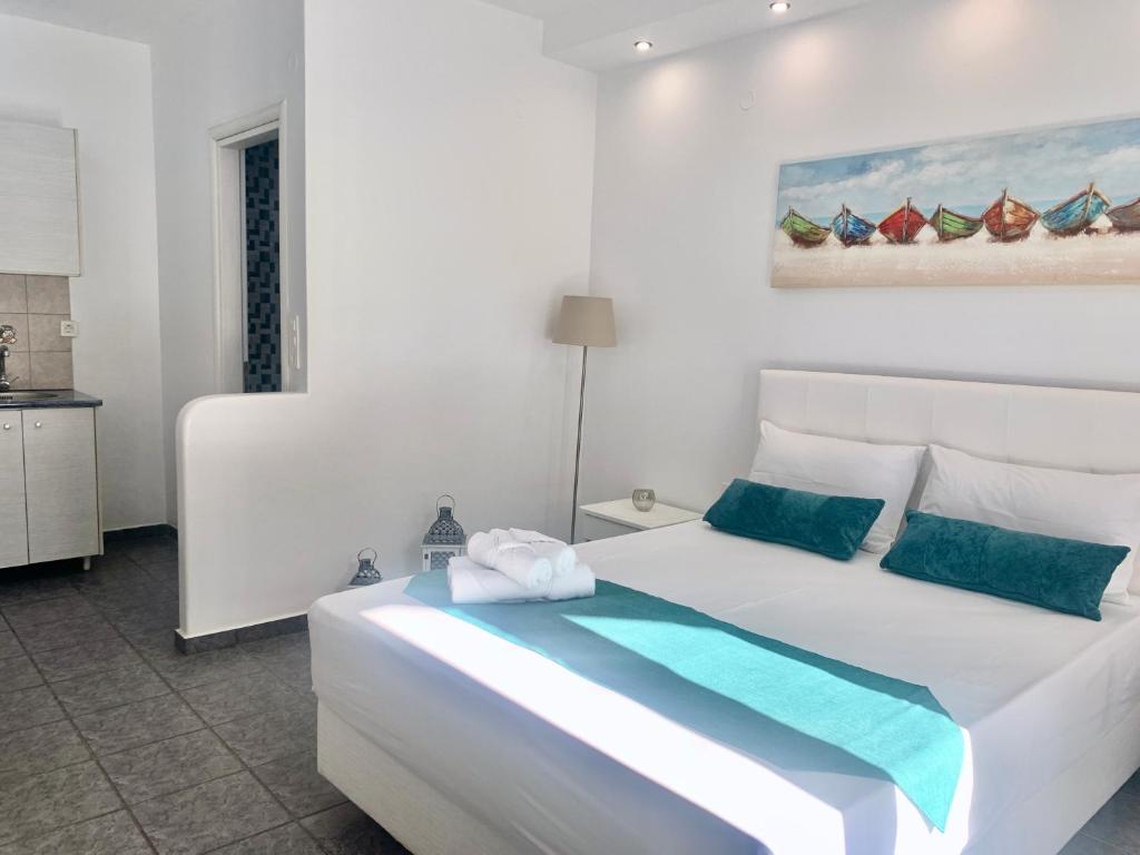 阿达玛斯阿尼莫斯公寓酒店的白色卧室配有白色大床和蓝色枕头