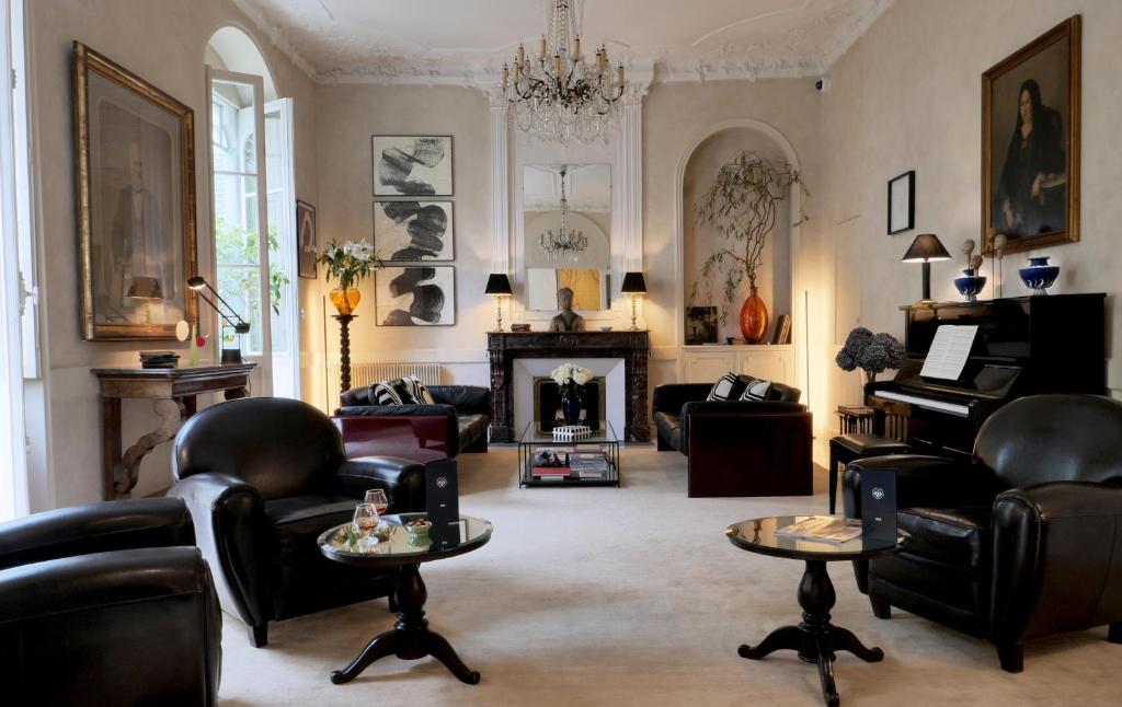 波城Hôtel Bristol Pau的客厅配有皮革家具和壁炉