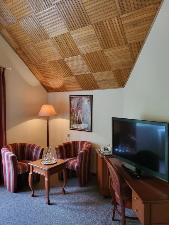 帕兰加Vila Florena的客厅配有2把椅子和平面电视