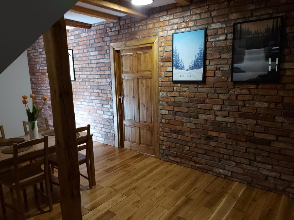 斯克拉斯卡波伦巴Zielony Jeleń - sauna i jacuzzi的一间设有砖墙和木门的房间
