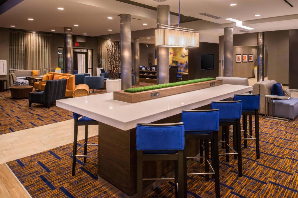 杰克逊维尔杰克逊维尔万豪万怡酒店的酒店大堂的酒吧,设有蓝色凳子
