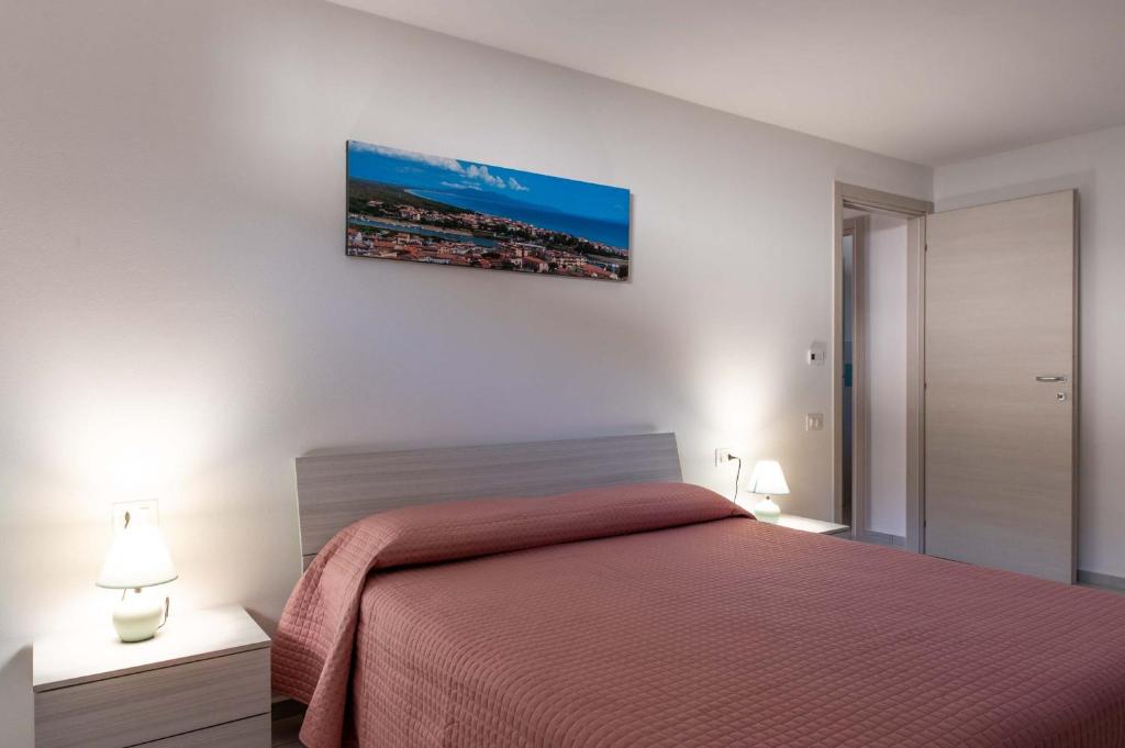 福洛尼卡CAMPI ALTI AL MARE APARTMENTS的一间卧室配有一张红色的床和两盏灯。