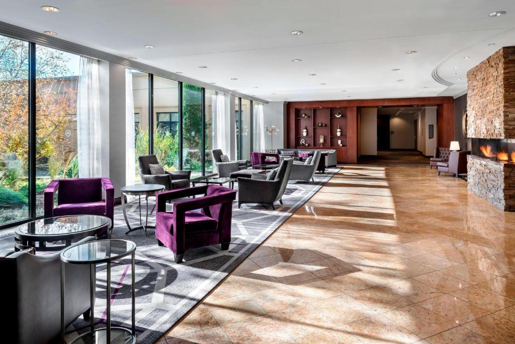 多伦多多伦多机场喜来登会议中心酒店的大堂设有紫色椅子、桌子和窗户