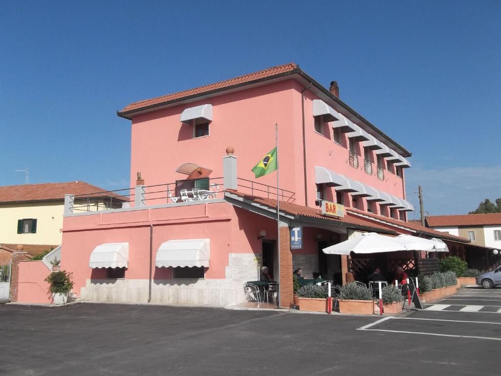 阿尔比尼娅雷纳托酒店的粉红色的建筑,上面有旗帜