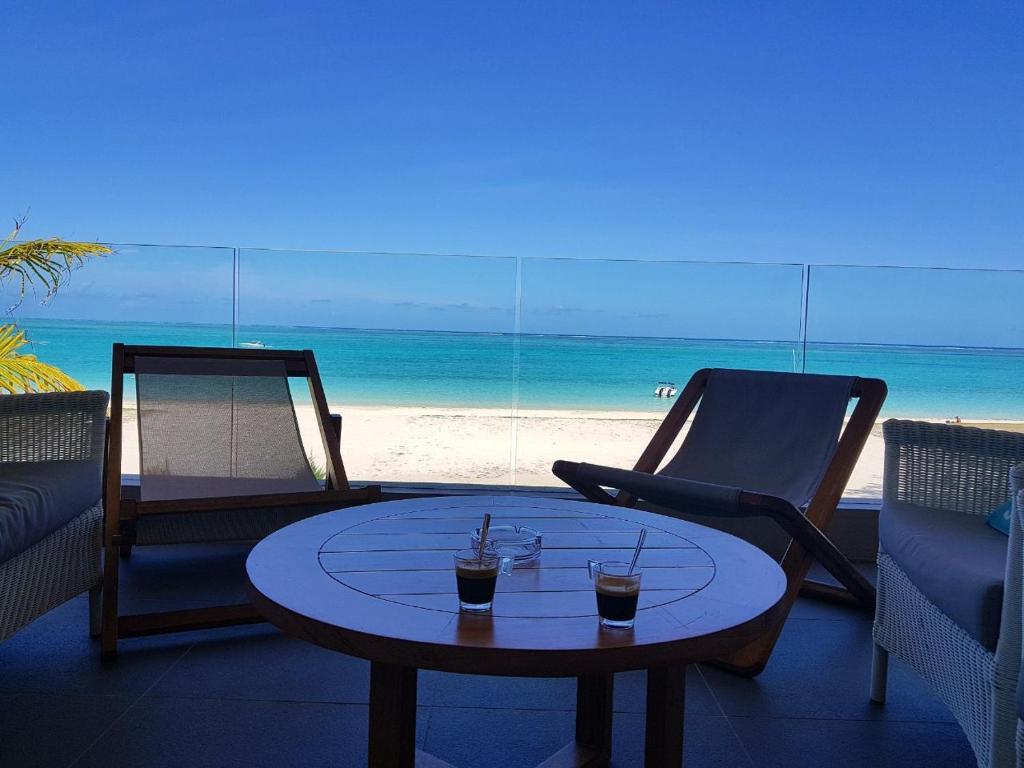 埃斯尼角Summer Breeze - Beachfront - 3 Bedrooms Suite的海滩咖啡桌上的两杯饮料