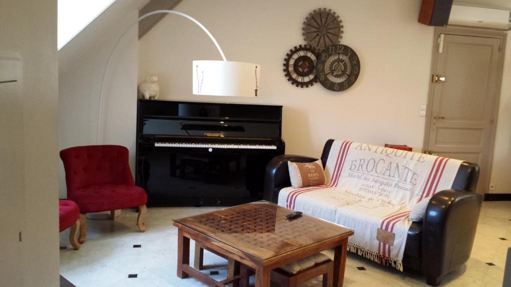 圣马丹勒博瓦雷公寓的带沙发和钢琴的客厅
