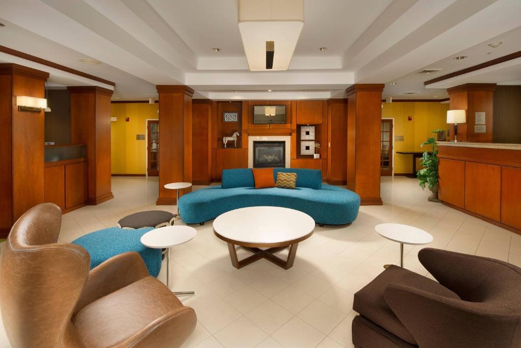 韦科瓦可北麦瑞特费尔菲尔德客栈的客厅配有蓝色的沙发和桌椅