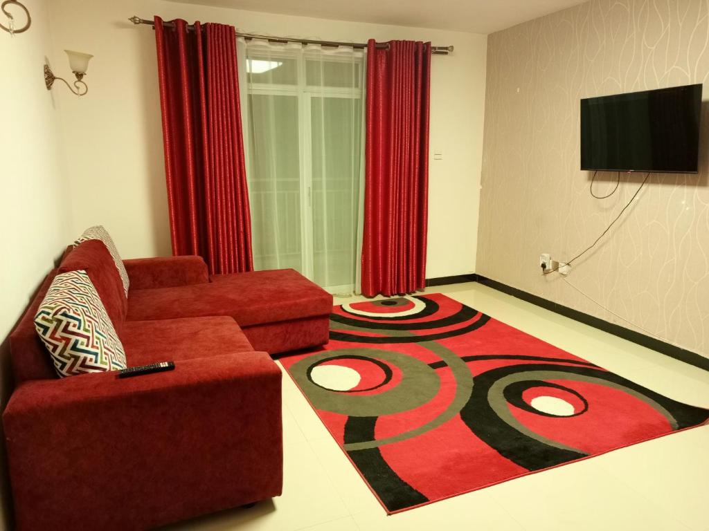 内罗毕Casa Tranquilla - JKIA的客厅配有红色沙发和地毯