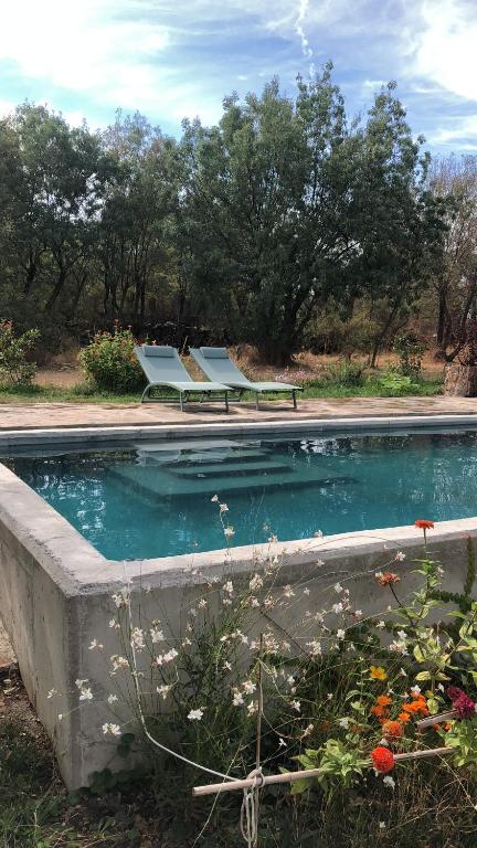 Ortigosa del MonteLas Casas del Palomar I & II的一个带两把椅子和长凳的游泳池