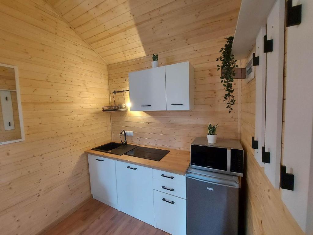 SpytkowiceChatka pod orzechem的小厨房配有白色橱柜和炉灶。