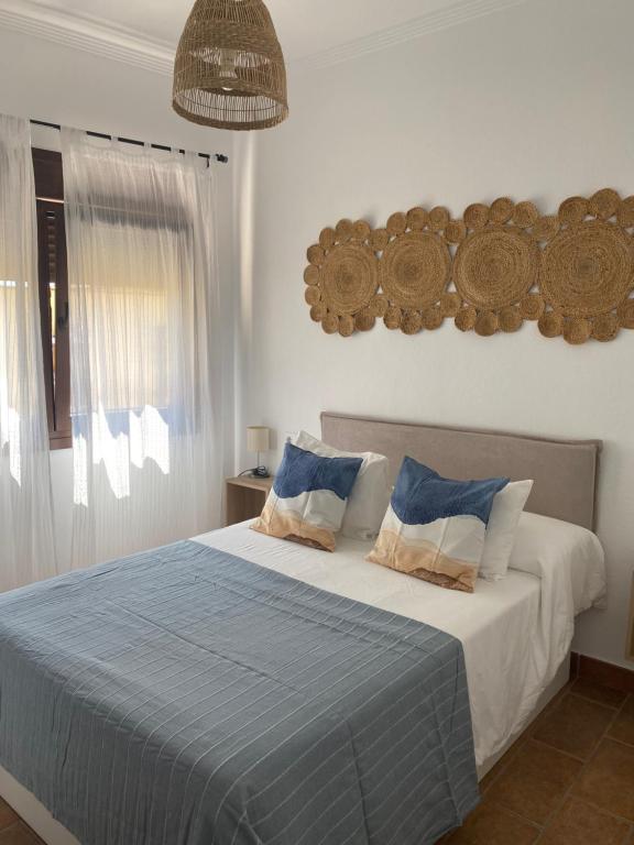 博罗尼亚Habitaciones Carmencita的一间卧室配有一张带蓝色床单的床和一扇窗户。