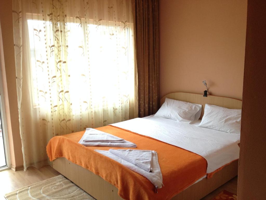 多亚马伊Casa Mario的一间卧室配有一张带橙色毯子和窗户的床。