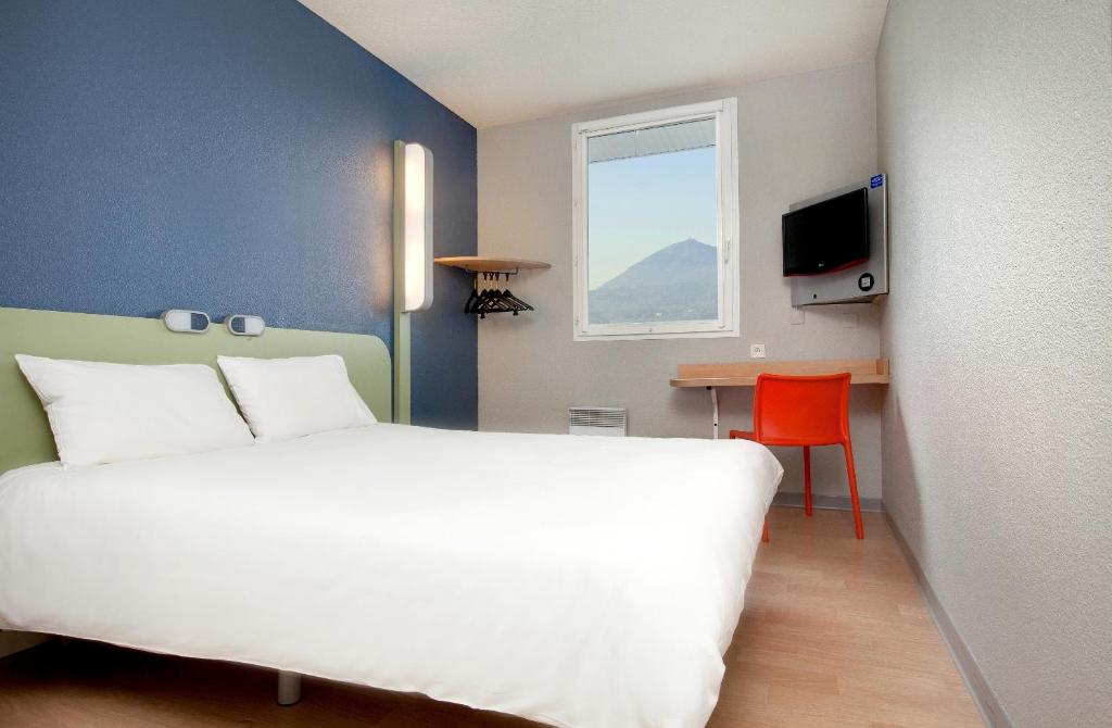 里永宜必思快捷酒店克莱蒙费朗北里翁的卧室配有白色的床、桌子和窗户。