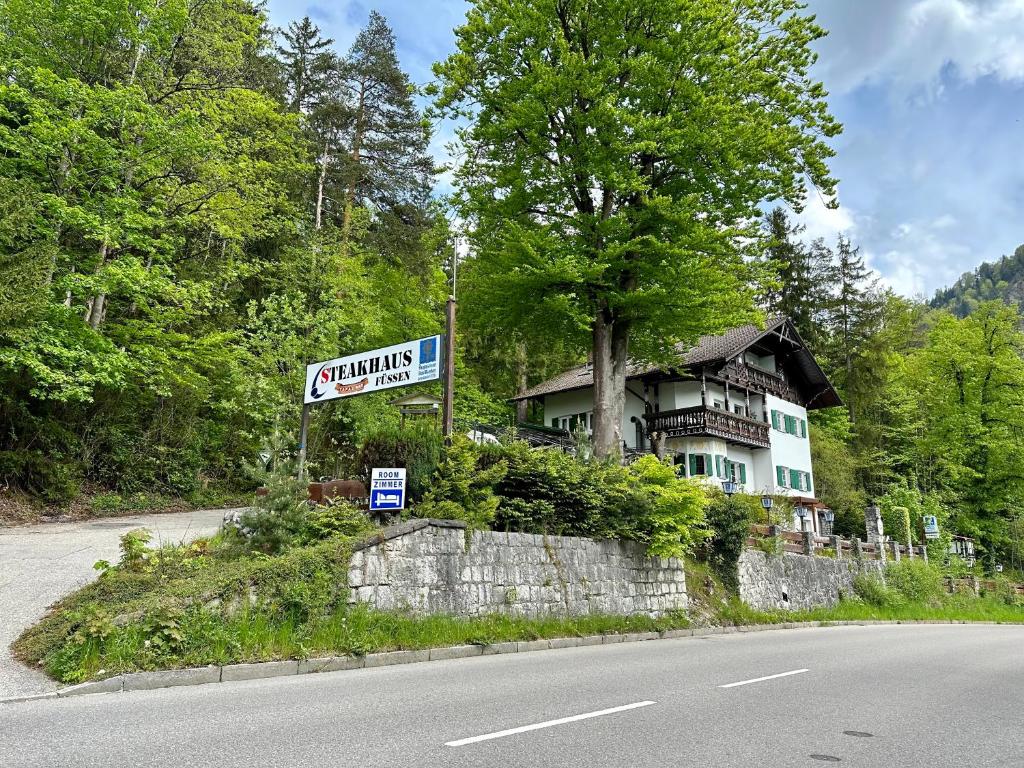 福森Pension Steakhaus Füssen的路旁有标志的房子