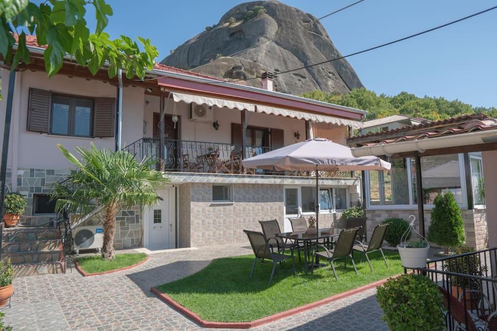 卡兰巴卡Villa Nefeli的房屋配有桌椅和岩石