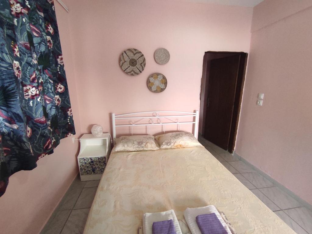 阿吉亚特拉萨Niki's house的一间小卧室,配有一张床和墙上的时钟