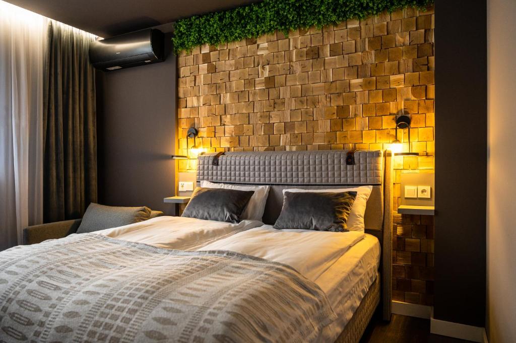 韦林格勒Какао Апартамент Велинград的一间卧室设有一张带砖墙的大床