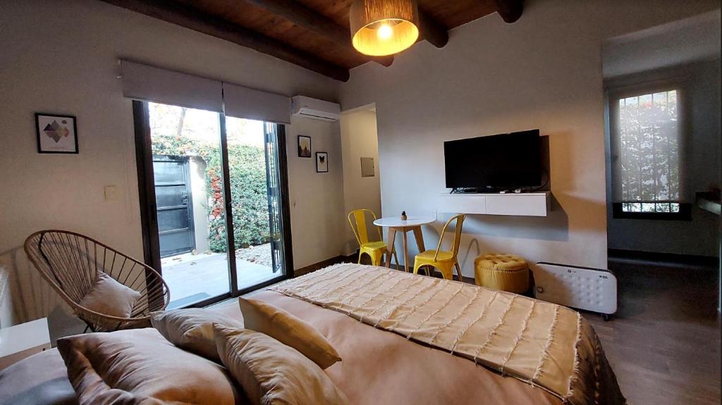 查克拉斯德科里亚Moderno departamento para dos personas en Chacras de Coria的一间卧室配有一张床、一张沙发和一台电视。